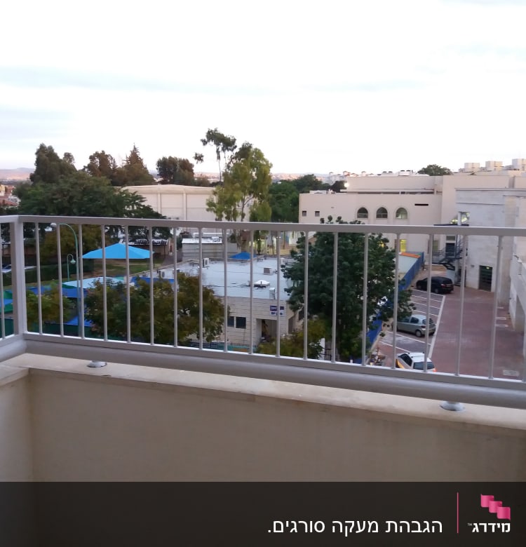 מעקה מתכת במרפסת עם נוף עירוני ברקע